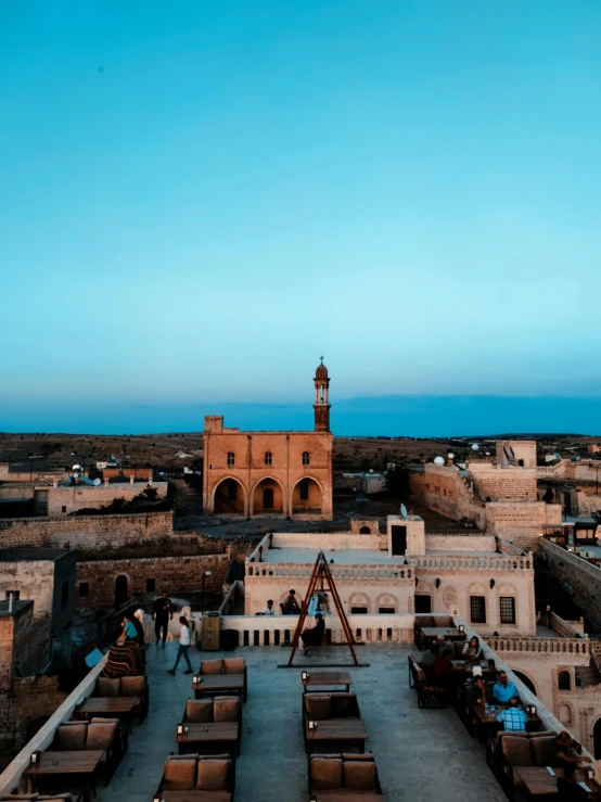 the view from the top of a building at dusk, with rooftops in the foreground