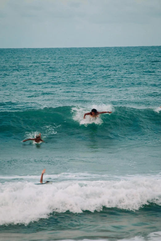 three people are in the water swimming and surfing