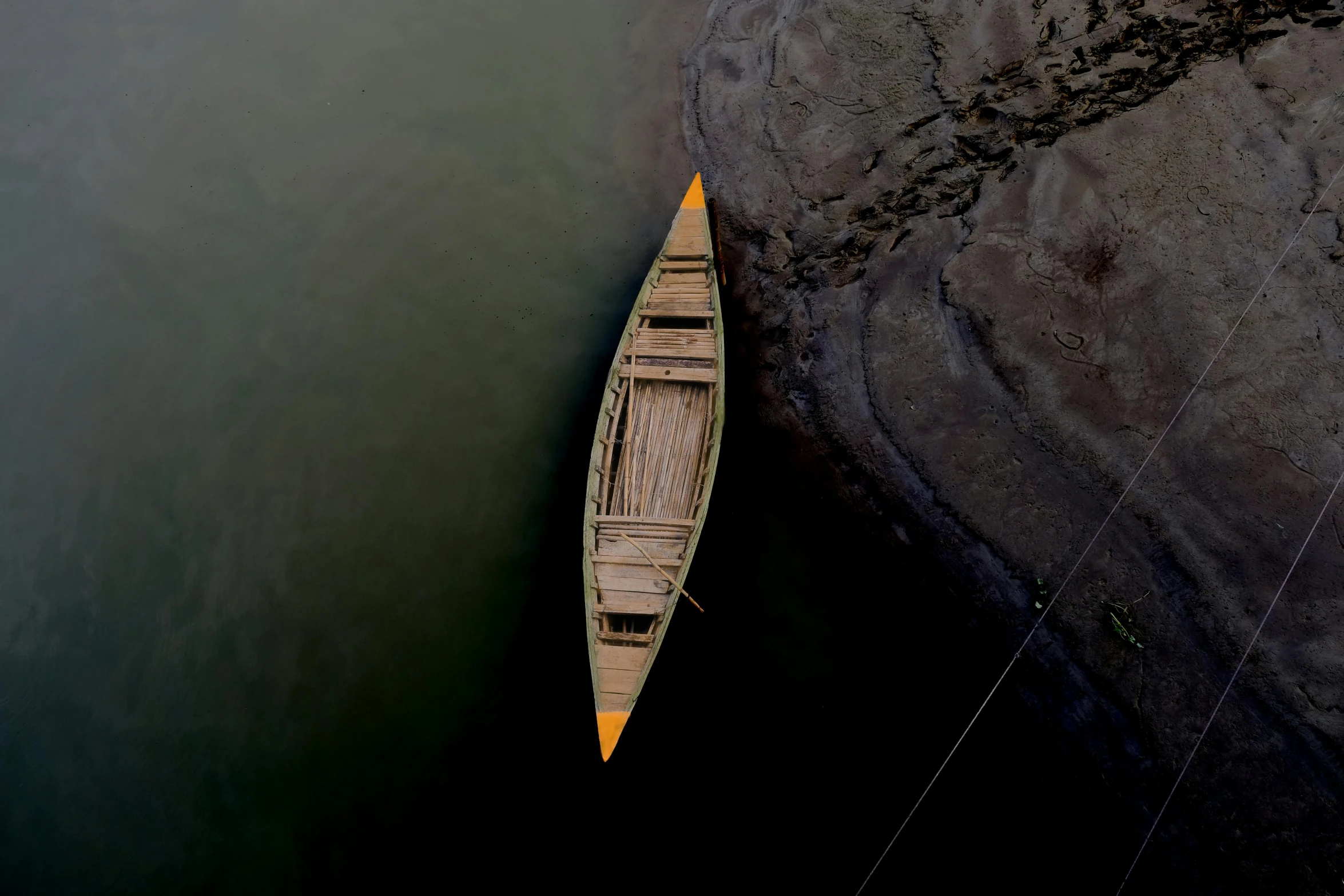 a small wooden boat tied to a dock