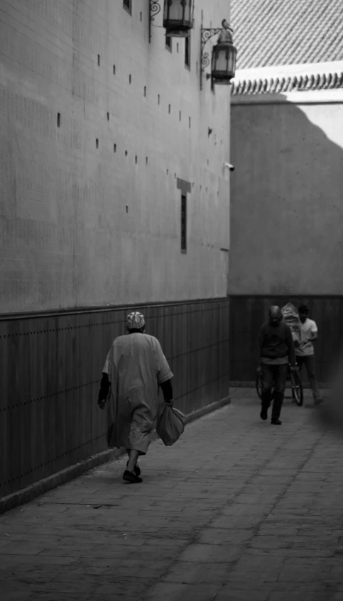 a person walks down a street past some buildings