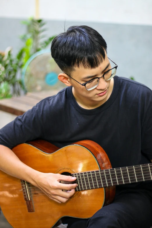 a man that is sitting down with a guitar