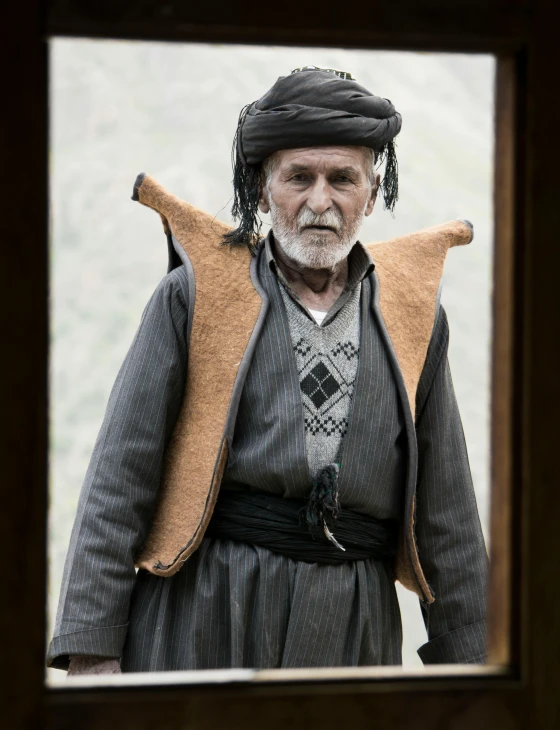 an elderly man stands in front of an open doorway