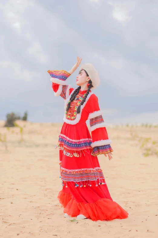 a woman in a long red dress on the beach