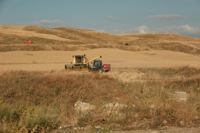 two farm trucks in a dry brown field