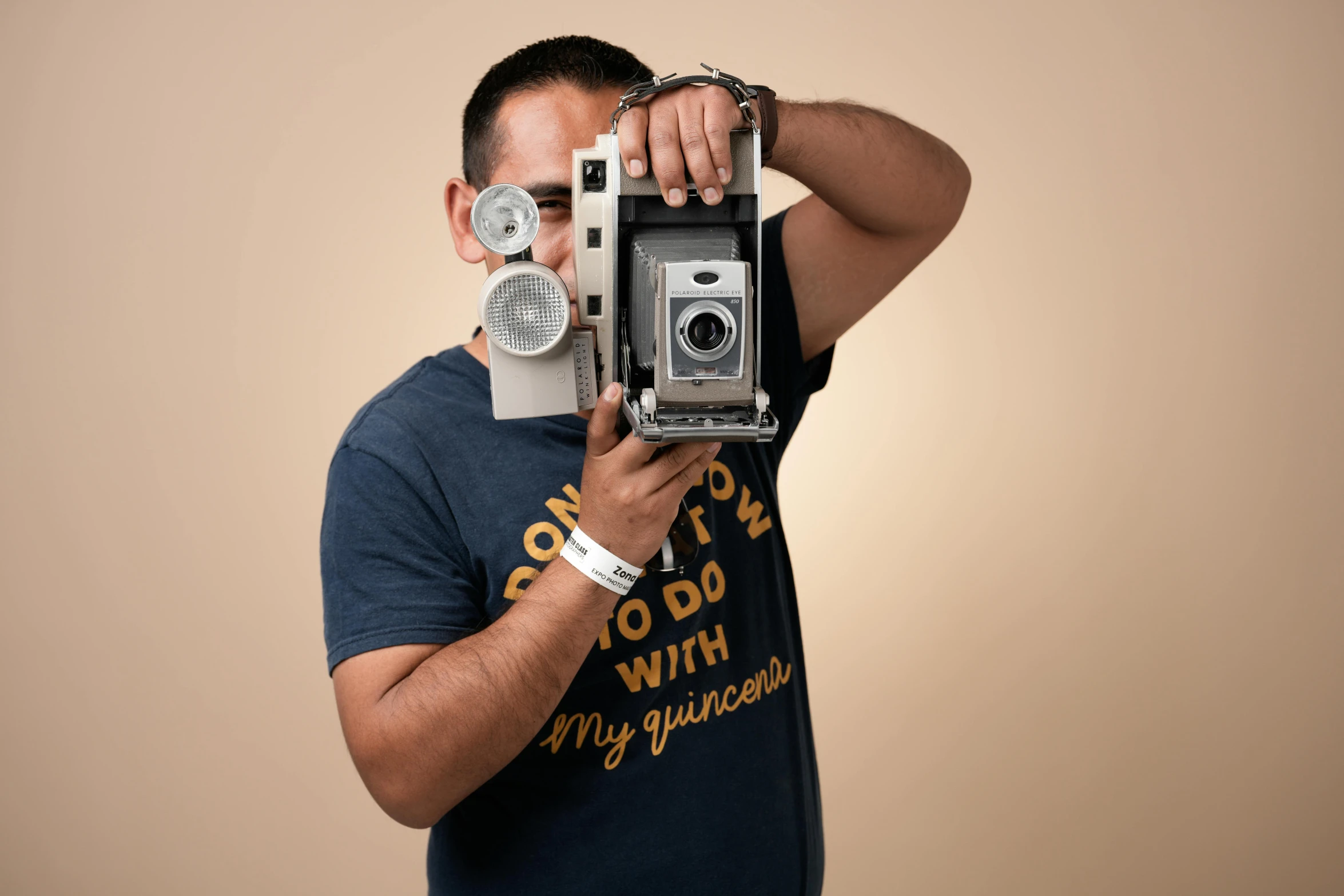 a man holding up a vintage camera to his face