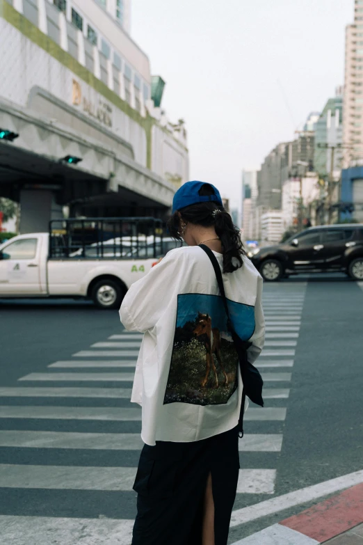 a woman in the street looking at a car passing by