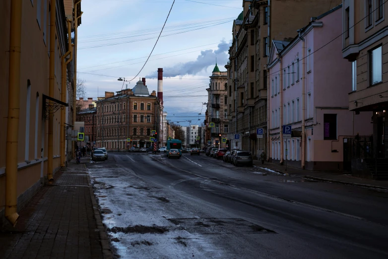 a street lined with parked cars and apartment buildings