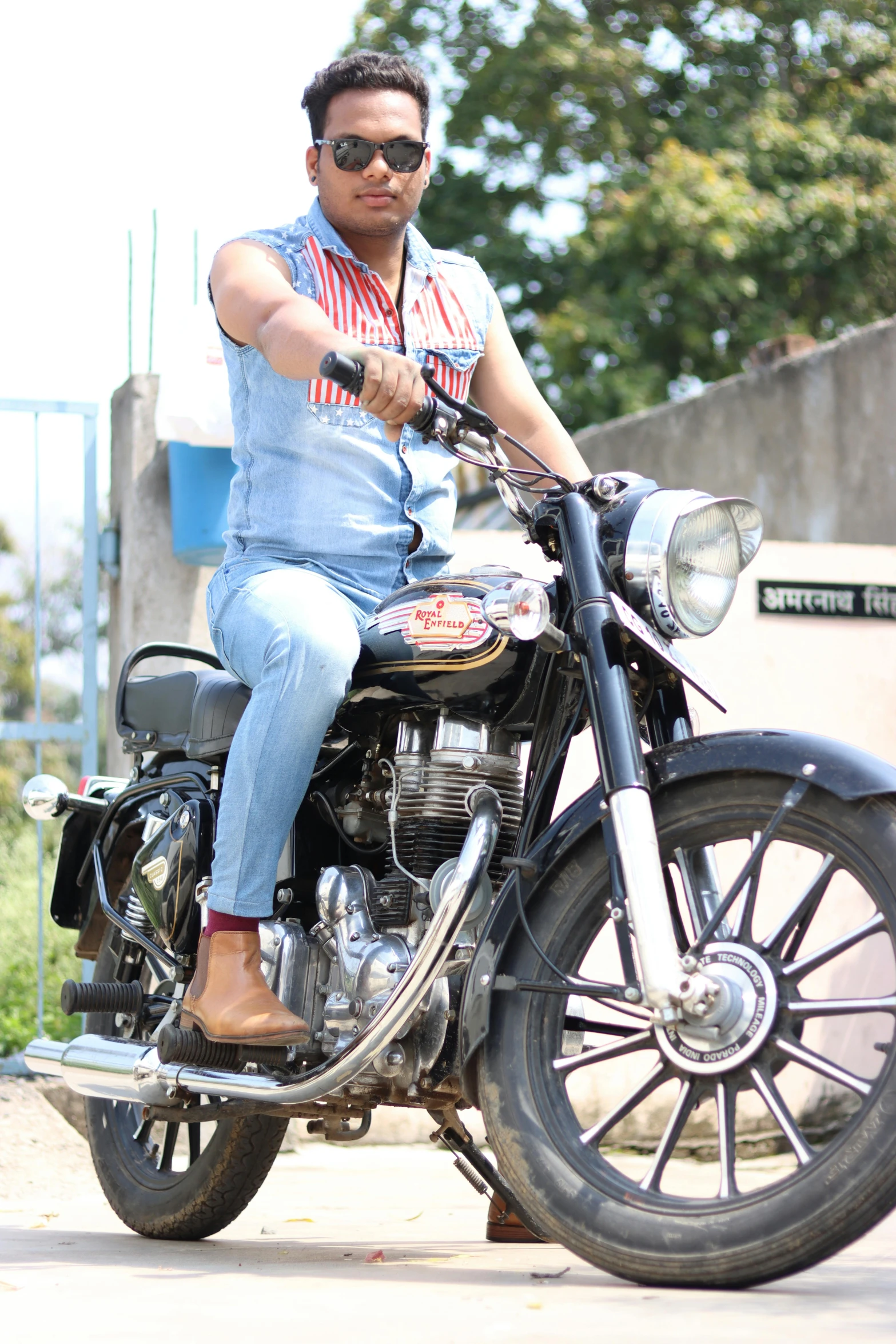 a man with shades and a pair of jeans on sitting on a motorcycle