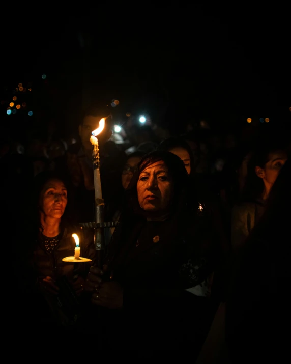 group of people holding up a candle at night