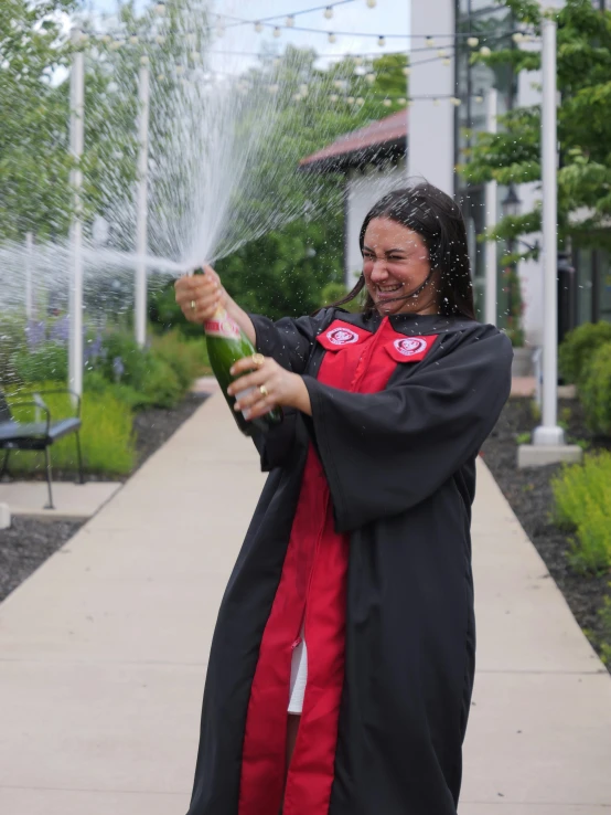 a smiling woman holding a bottle and sprinkles it