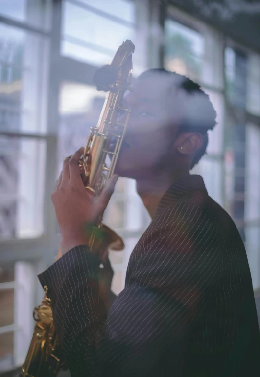 a man that is playing the saxophone behind a glass