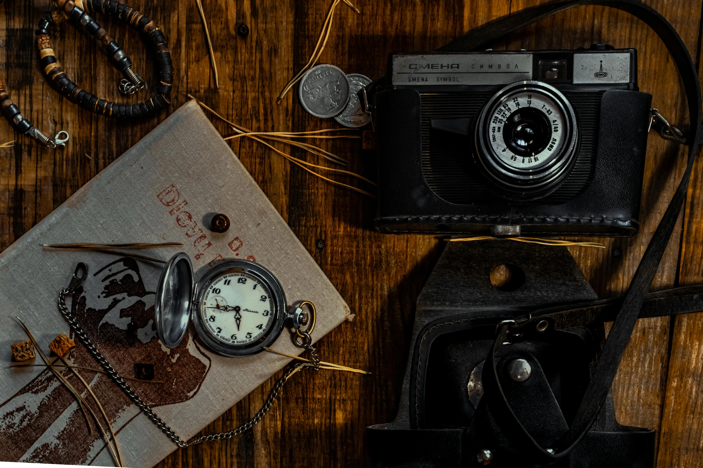 an old analog pocket watch and compass near a map