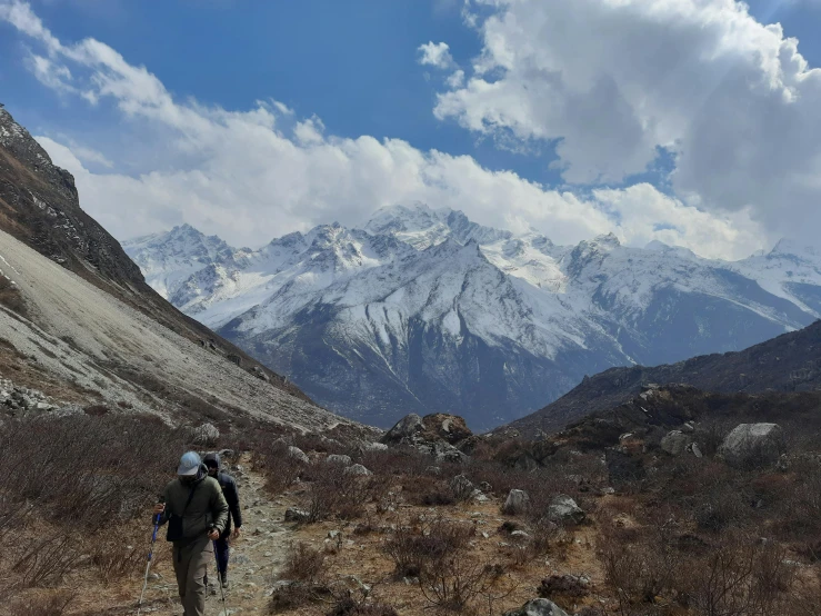 two hikers in the mountains trek through dried brush