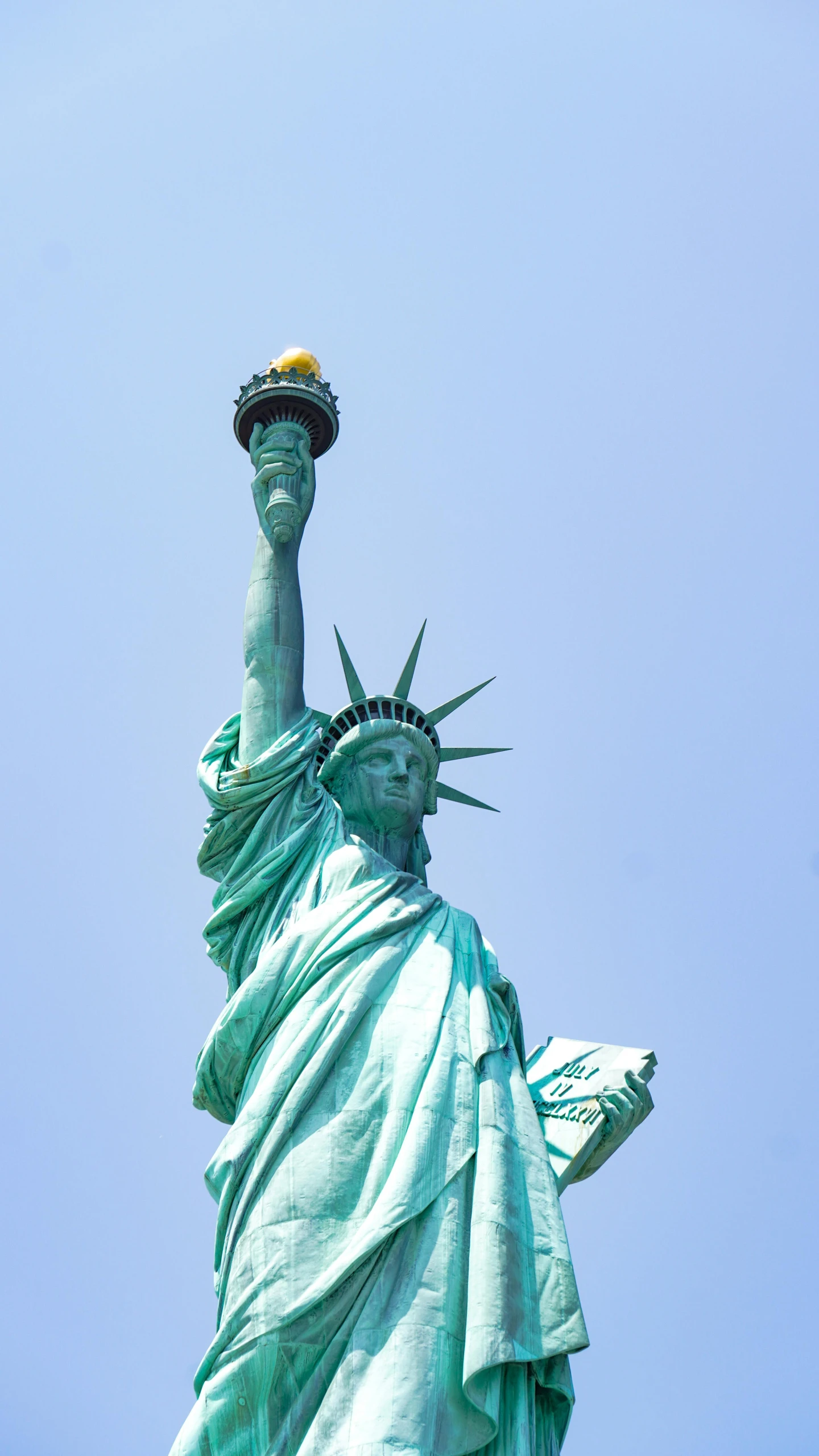 a big statue in a city under a blue sky