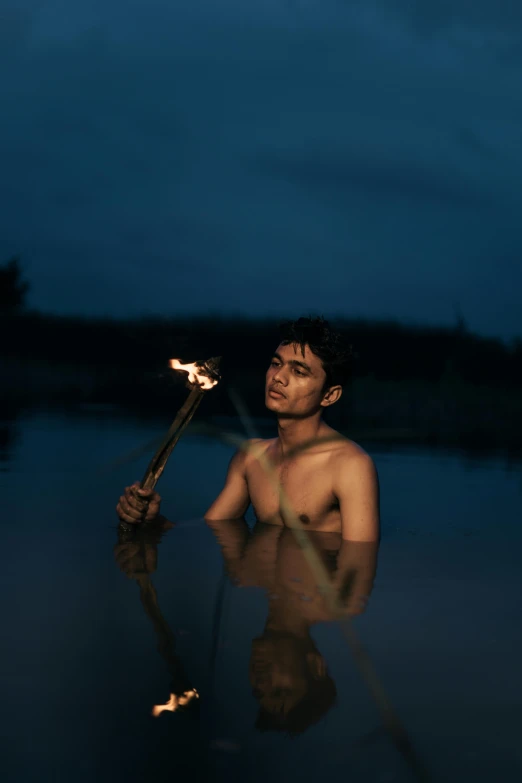 a man is holding a stick in the water