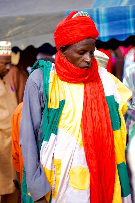 a man in colorful scarf and headdress in a crowd