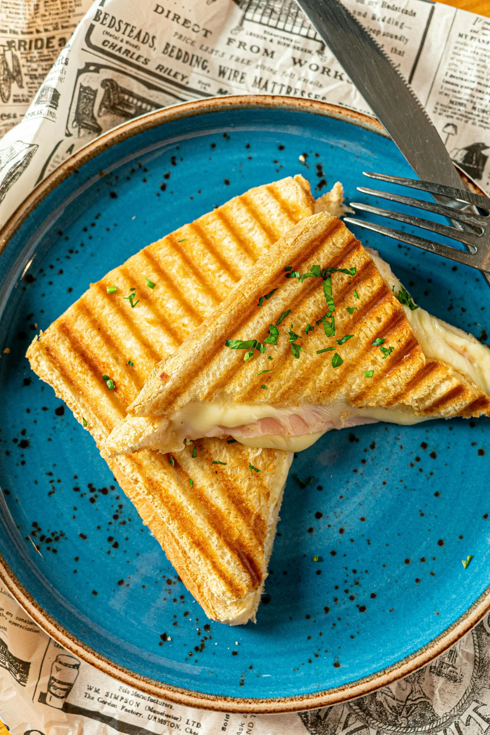 a ham and cheese sandwich is on a blue plate