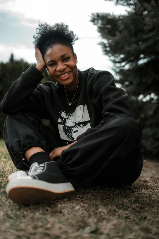 a woman posing for the camera in front of some trees