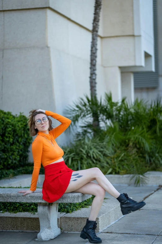 young woman sitting on a bench in front of the office building