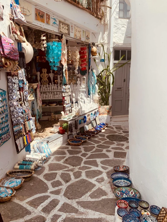 street market with many products, plates, and vases