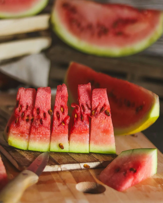 slices of watermelon and some knifes are being cut in pieces