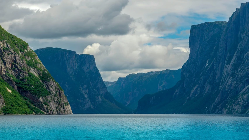 the mountain tops are near very high rocks and blue water