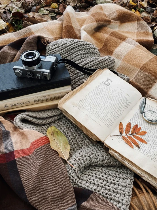 a pile of books with a camera on top