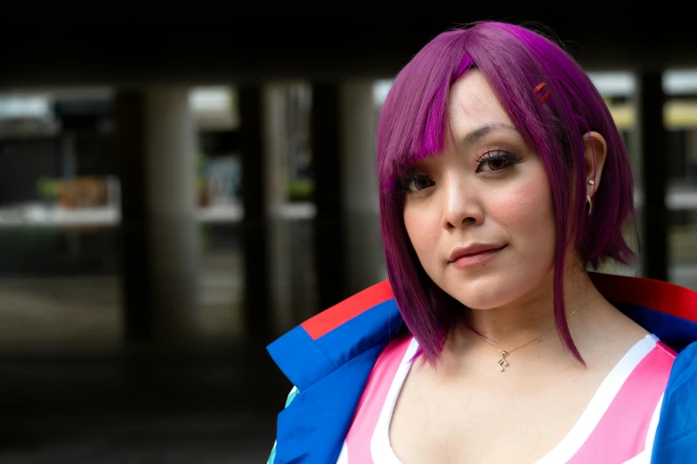 a woman with purple hair wearing a colorful jacket