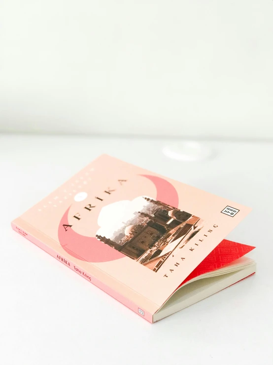 a white book with pink paper and a red cover