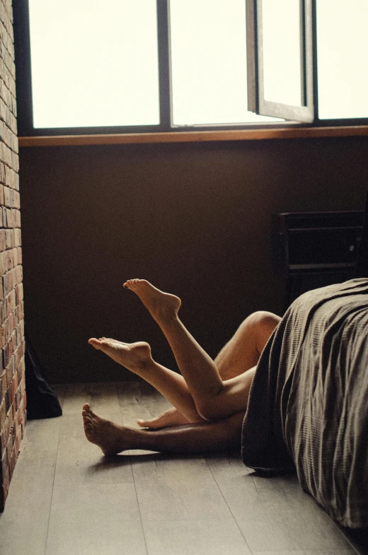 woman lying on floor in dimly lit room next to window