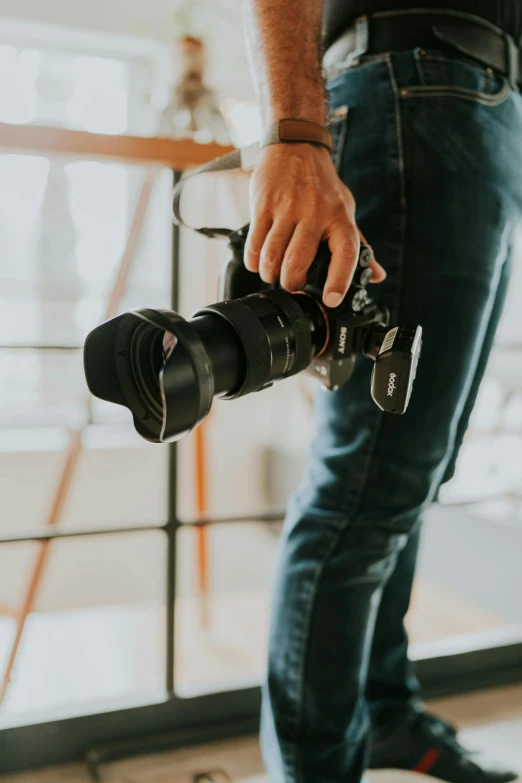 man standing on the ground with two canon cameras in his hands