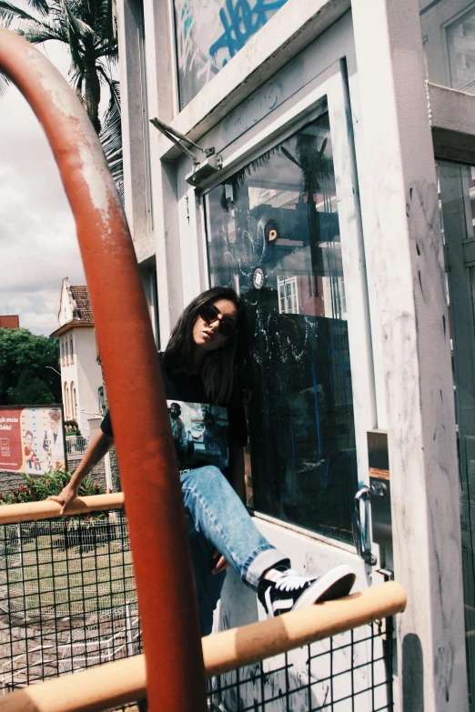 a woman leaning on the glass in front of a building