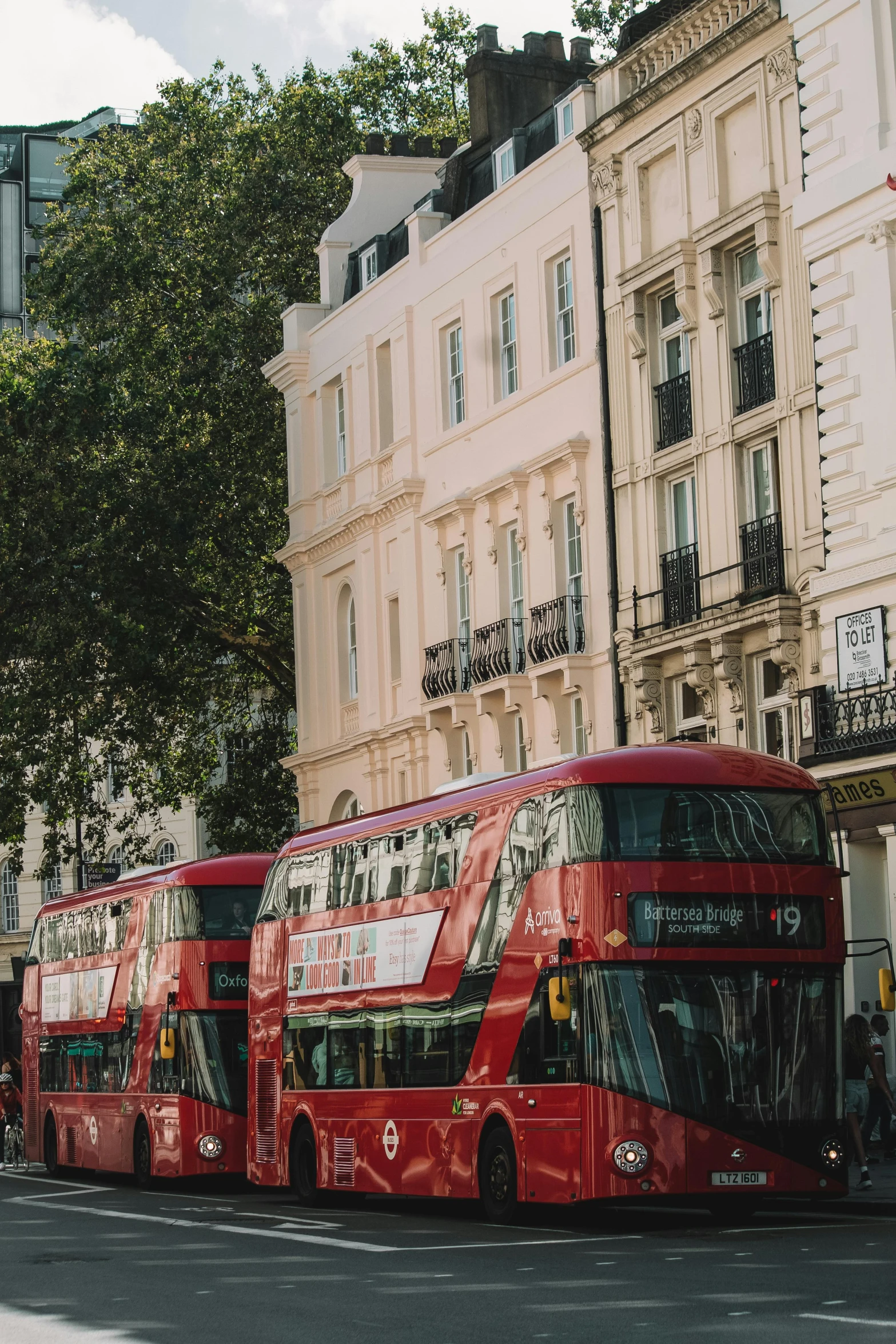 a line of two double deckered red buses on street