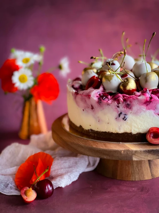 a small round cake with cherries on top