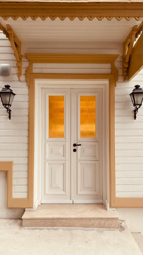 an ornate porch with two lights and a door