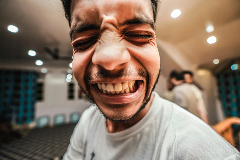 a man smiling at a camera with others in the background