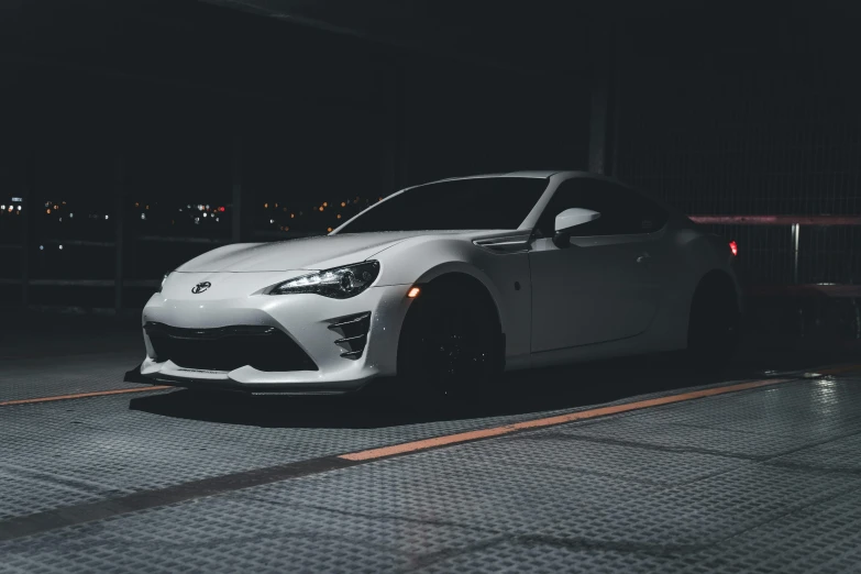a sports car parked in a parking lot at night