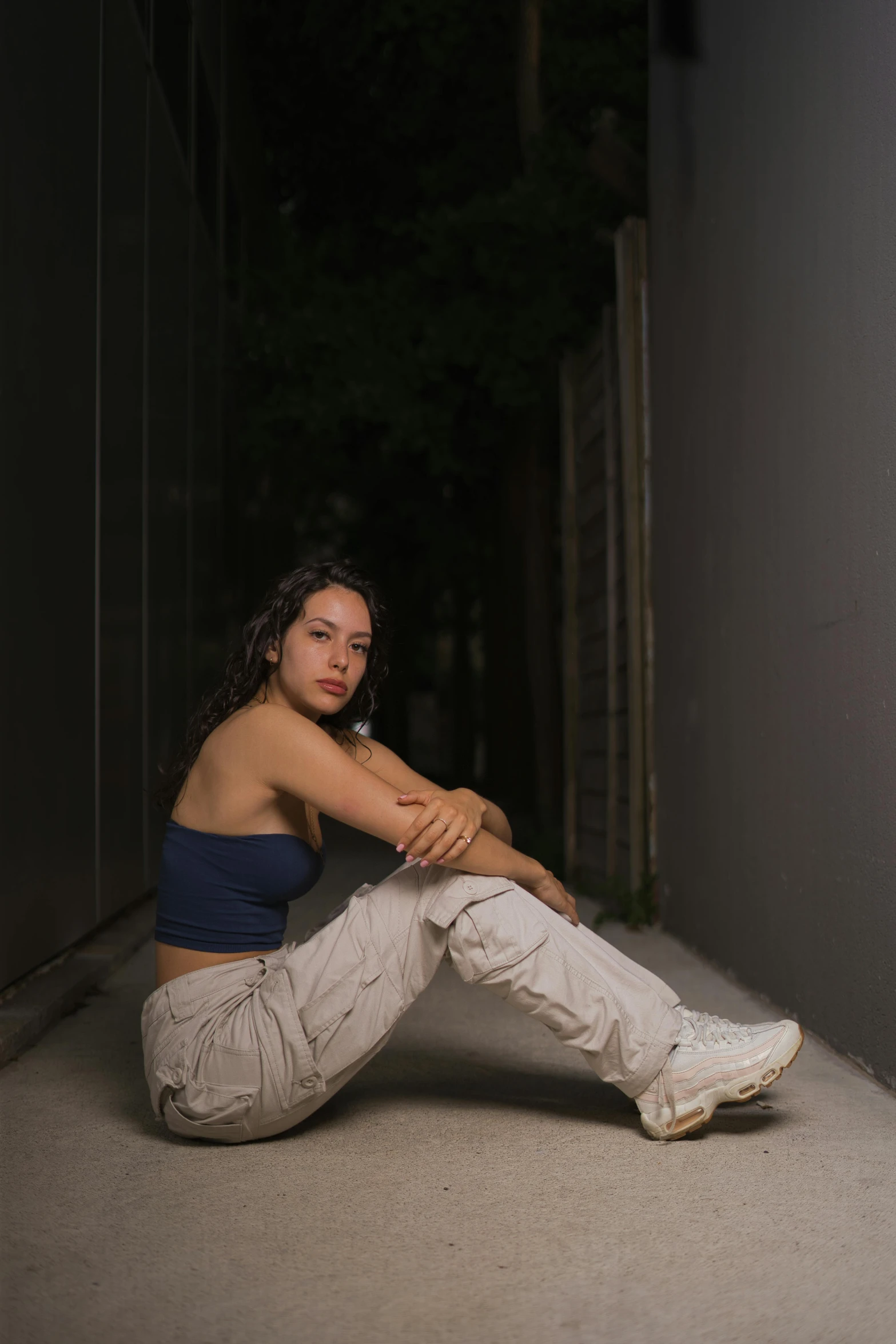 a woman in sports wear sits on the concrete floor