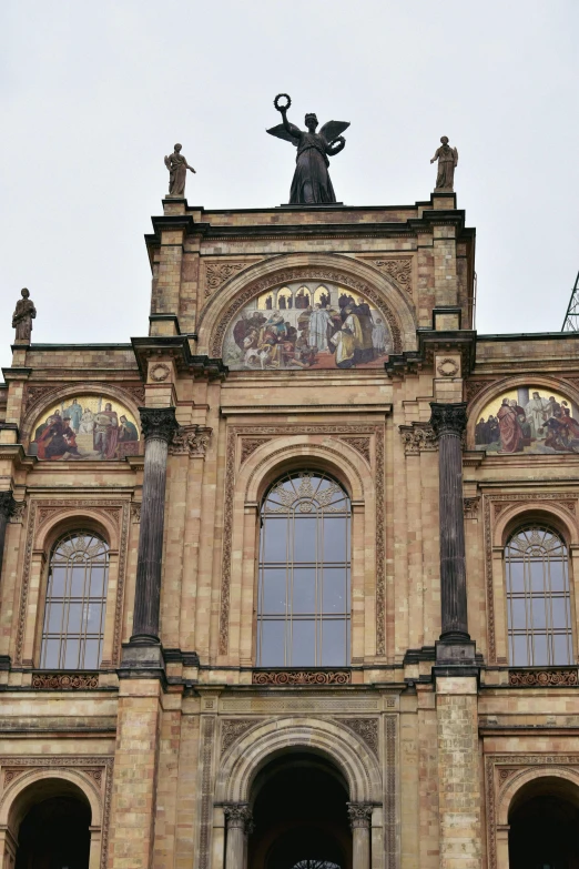 the facade of an old building with several windows and an angel statue on top of it