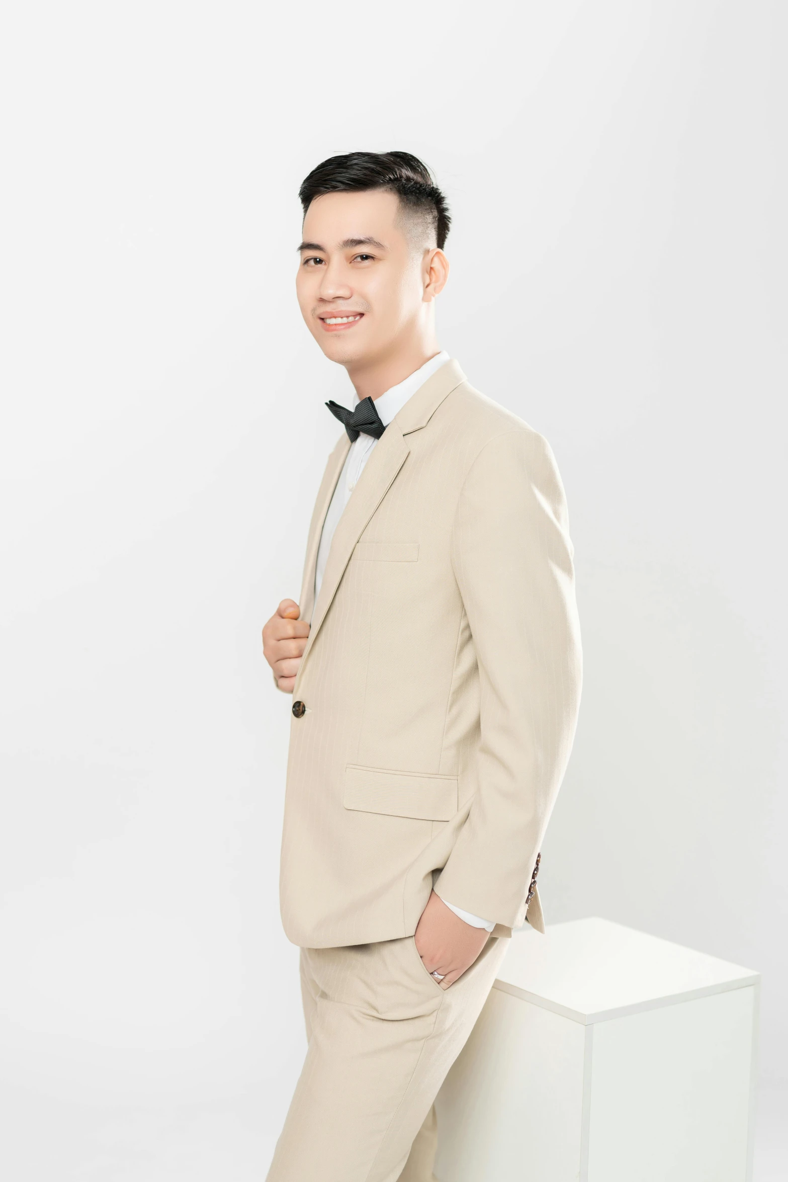 a man in a tan suit with black tie