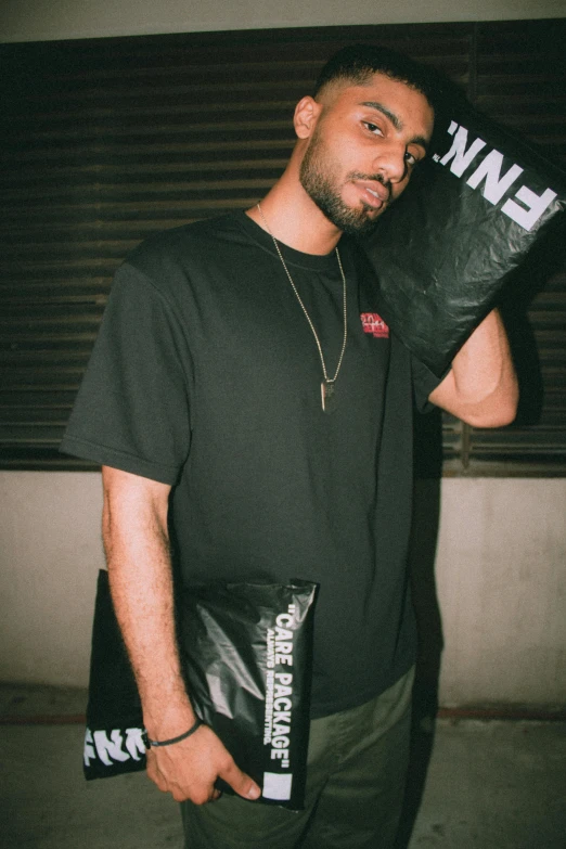 a young man holds up two boxing gloves