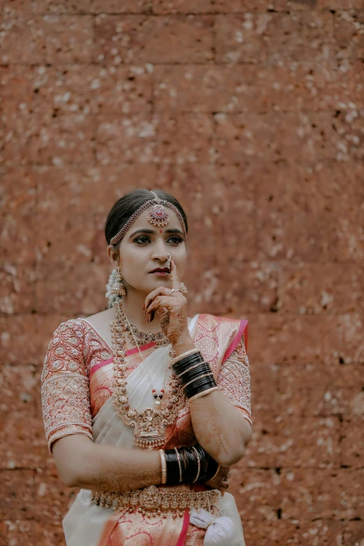 a woman in an indian wedding dress, holding a cat