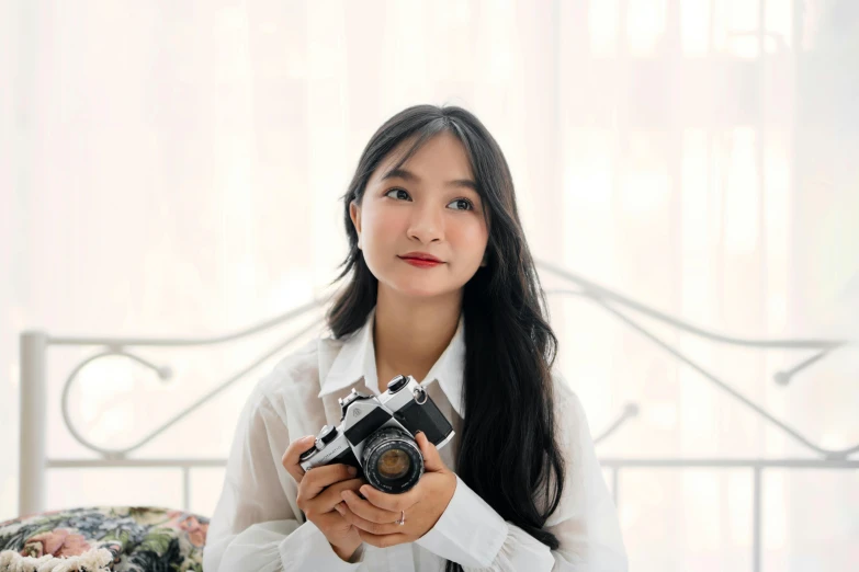 a woman holding a camera with a long black hair