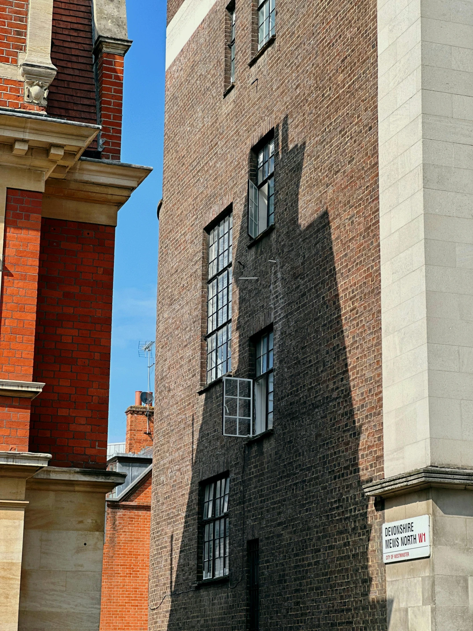 the side of a brick building, with a street sign on the outside