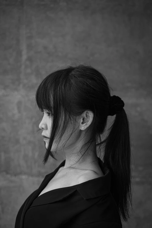 a woman with ponytail hair posing for a black and white po