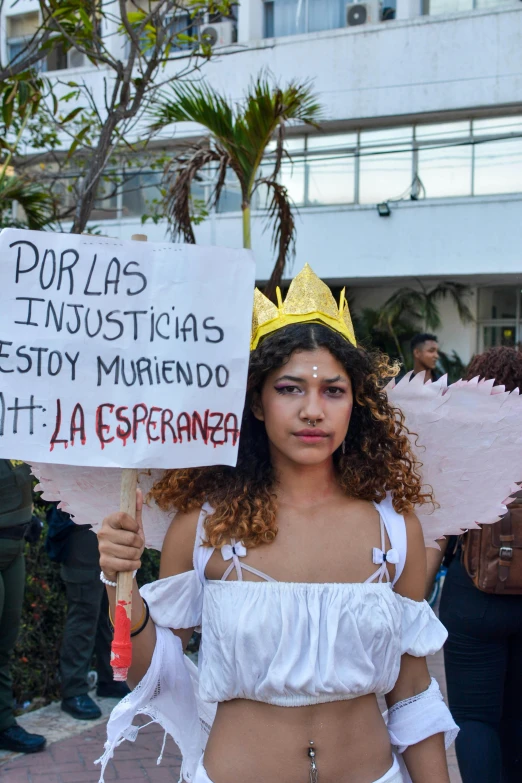 a woman holding a sign reading do not let her exprasm die