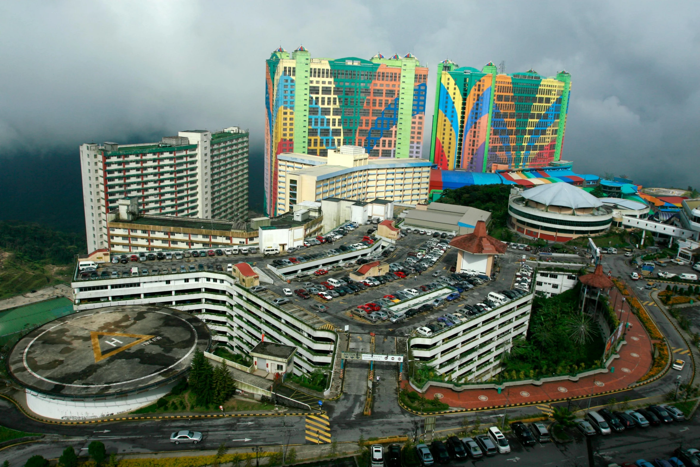 a city with buildings and cars in the parking lot