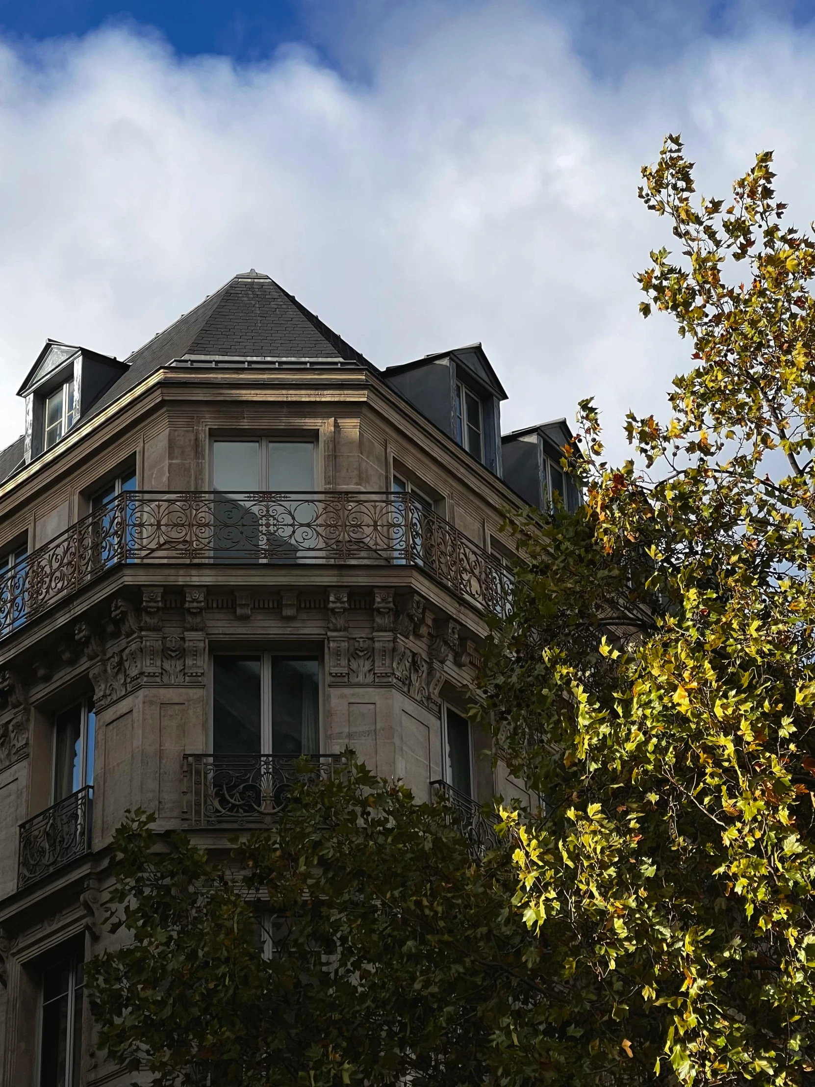 the top floors of a three story building surrounded by trees