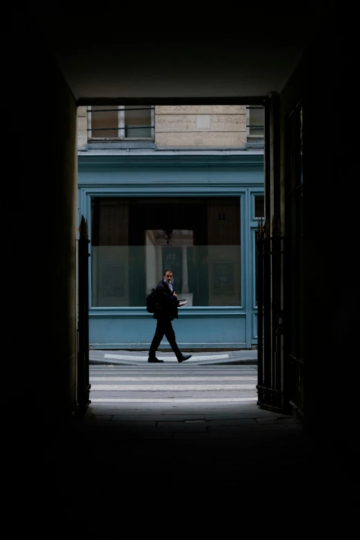 a man is walking down the street in front of a building