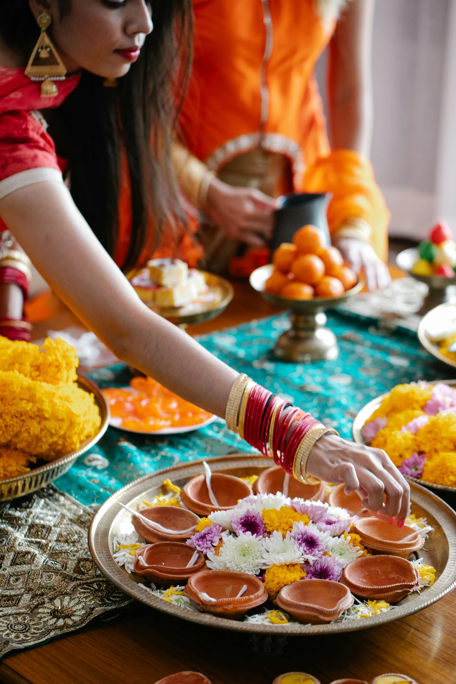 an indian woman decorates trays filled with flowers